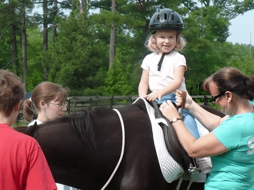 A woman and child riding on the back of a horse.