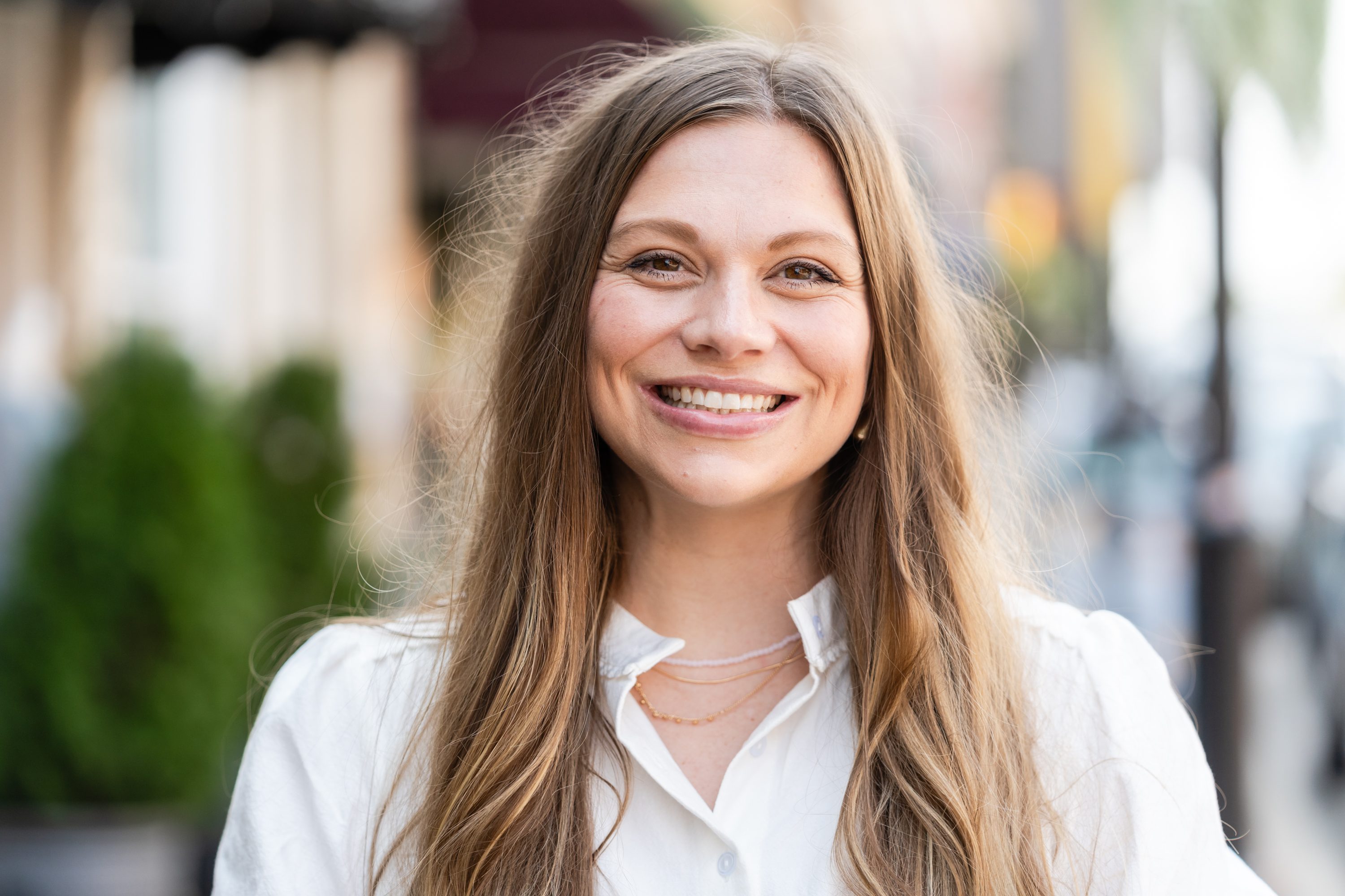 A woman with long hair smiles for the camera.