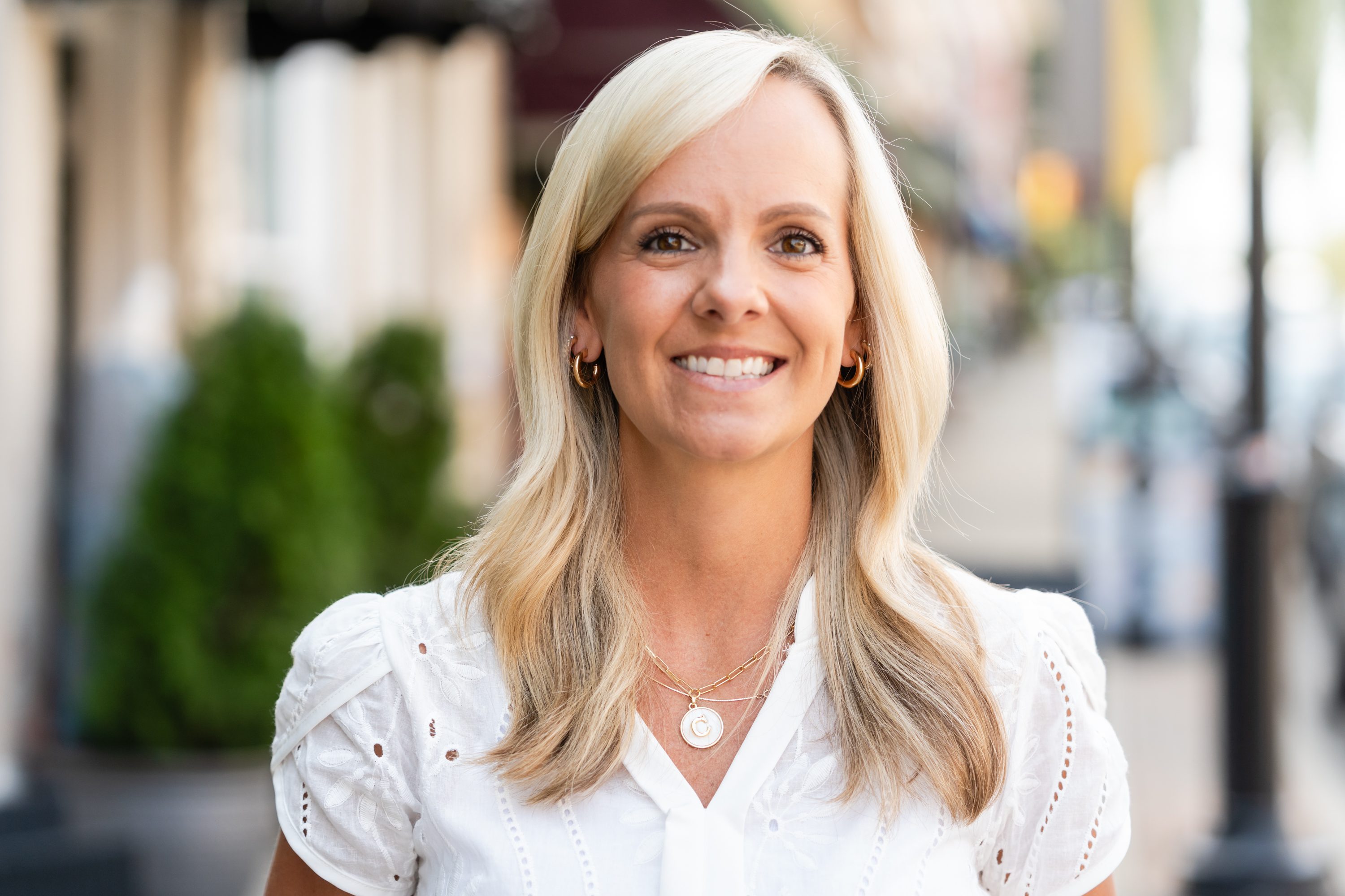 A woman with blonde hair wearing white shirt.