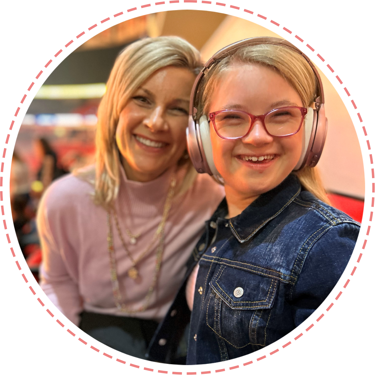 Two women smiling for a picture while wearing headphones.