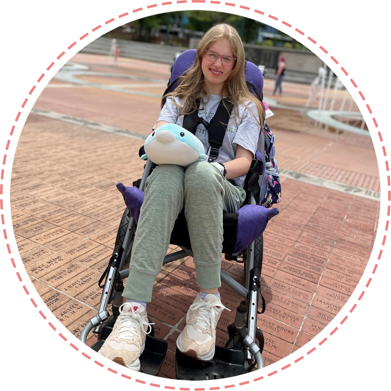 A woman sitting in a wheelchair on the ground.