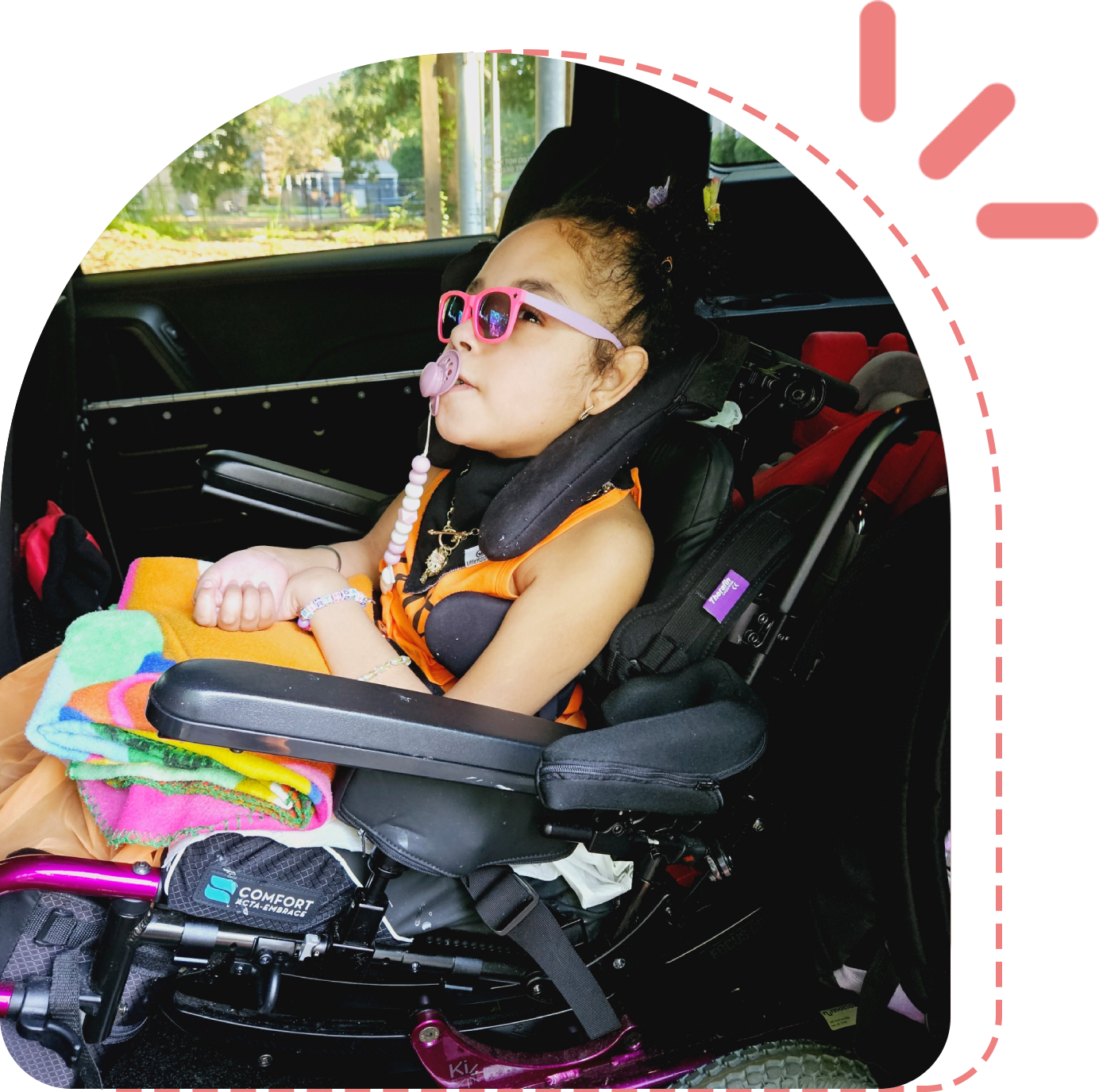 A young girl in a wheelchair with glasses on.